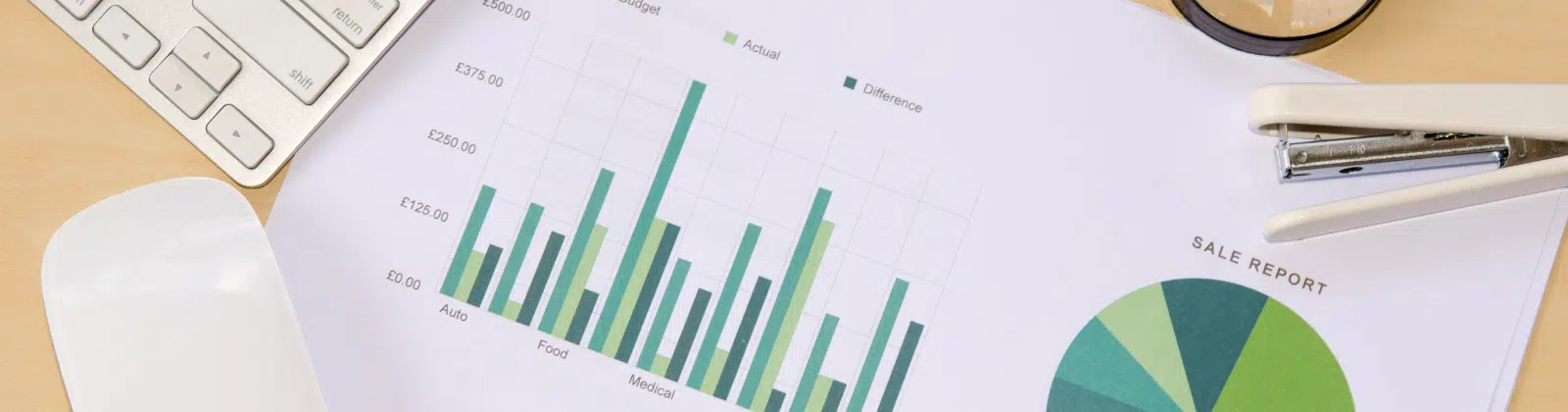 Charts and graphs on a desk with a mouse and keyboard