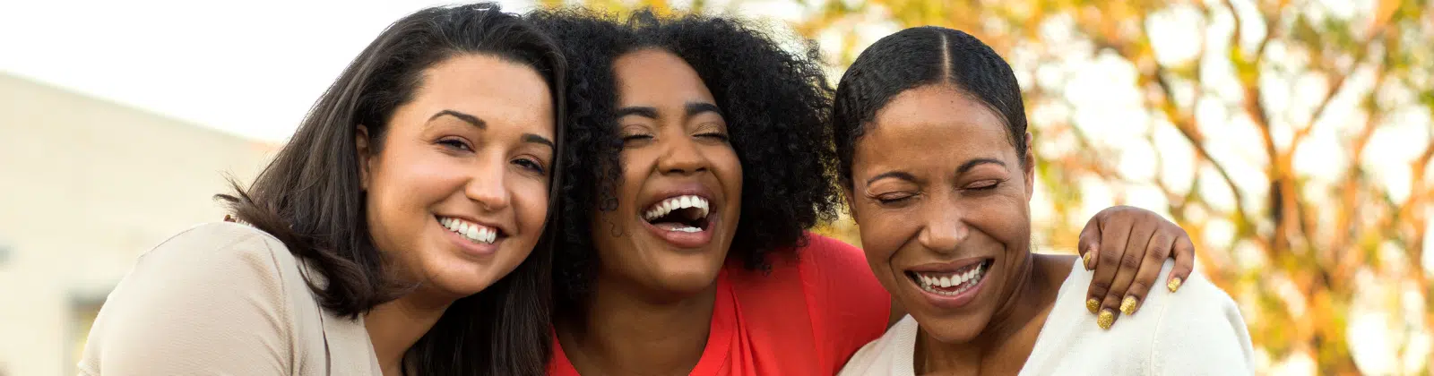 Three women of color laughing together
