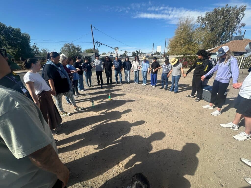 Border Southwest members praying outdoors in a circle